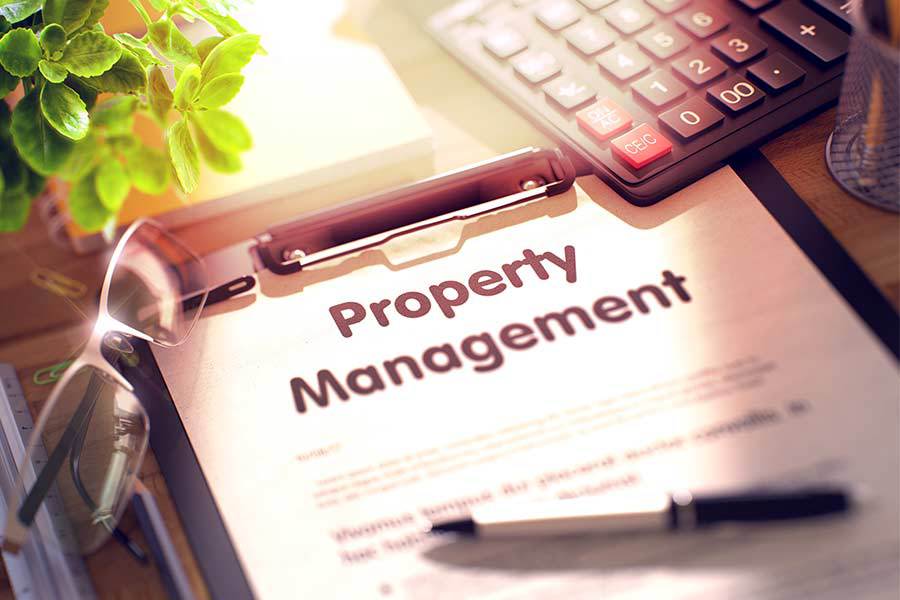 Property management notice on a clipboard with a calculator on a property managers desk.